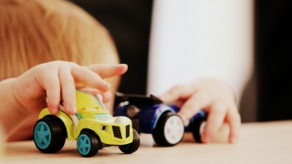 Close up of children playing with toy cars