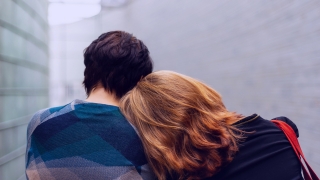 Woman resting head on partner’s shoulder